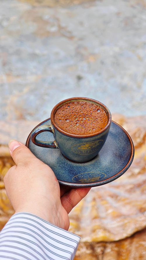 Free Close-up of a person holding a freshly brewed coffee in an artisan ceramic cup. Stock Photo