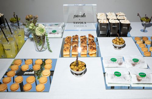 Free Stylish snack table featuring pastries, popcorn, olives, and drinks at an event. Stock Photo