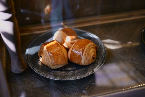 Free Delicious chocolate croissants on a metal plate in natural light, showcasing flaky pastry texture. Stock Photo