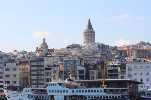 Free Galata Tower rises above the Istanbul cityscape with a ferry below. Stock Photo