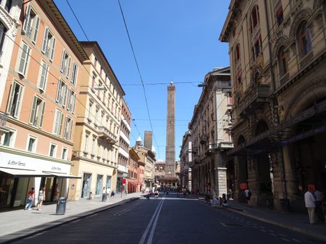 Street view of Bologna, Italy, showcasing its historical architecture on a bright summer day.