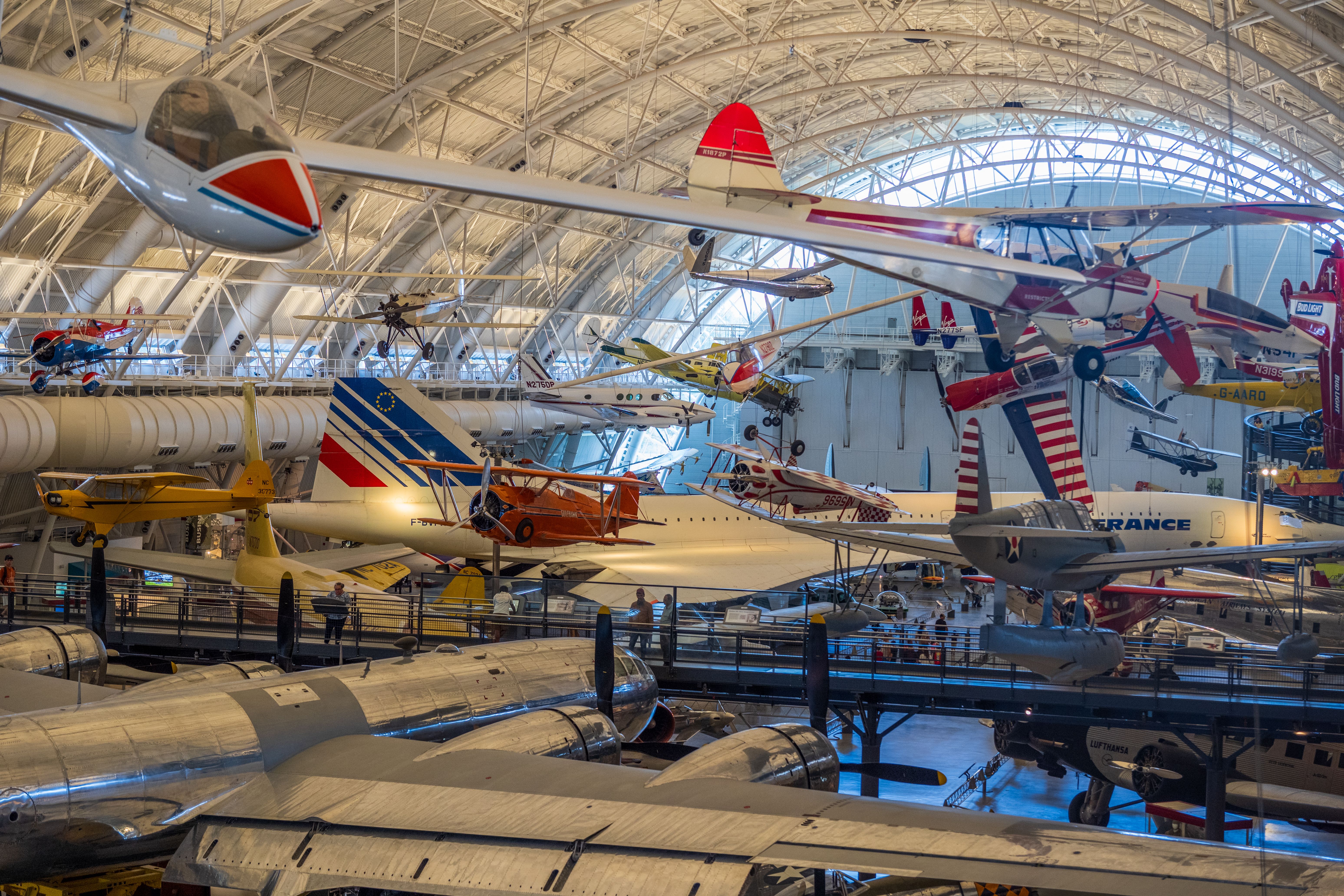 Aviation museum with various historical aircraft on display indoors. Visitors explore famous displays.