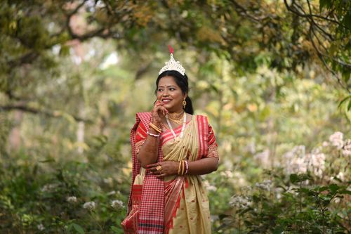 Free A Bengali bride poses outdoors wearing a traditional saree, showcasing cultural elegance. Stock Photo
