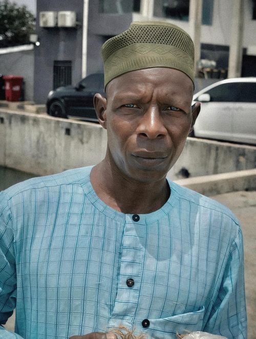 Free A man wearing traditional clothing stands outdoors, looking at the camera. Stock Photo