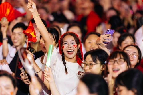 Free Excited young crowd celebrating with flags and face paint outdoors. Stock Photo