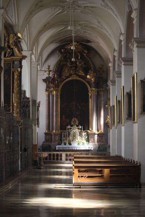 Free A beautiful church interior in Munich, Germany, featuring an ornate altar illuminated by sunlight. Stock Photo
