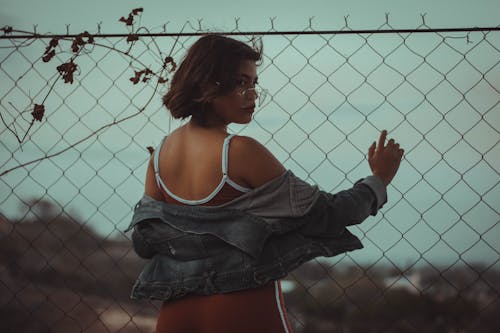 Woman Holding On A Fence