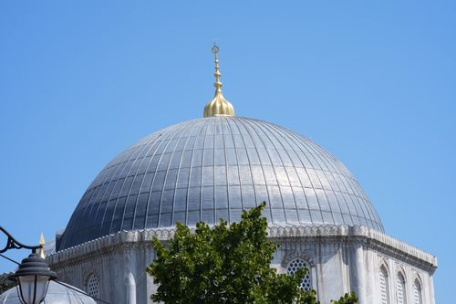 Free Beautifully adorned mosque dome with blue sky backdrop, highlighting Islamic architecture. Stock Photo