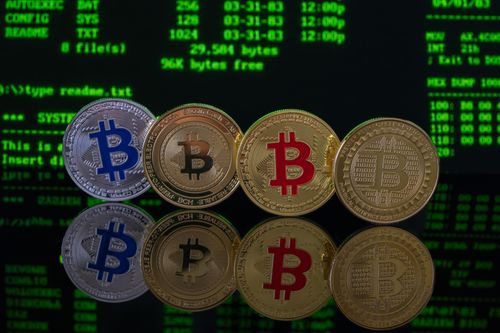 Free Image of Bitcoin coins reflected on a surface against a digital code background, representing cryptocurrency and digital markets. Stock Photo