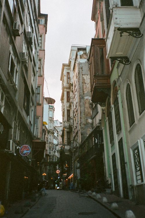 Free A quaint narrow street lined with historic buildings, capturing European charm and architectural beauty. Stock Photo