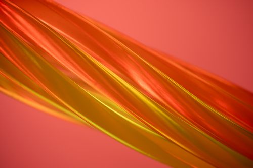 Free A dynamic composition of orange and yellow translucent curves on a pink background. Stock Photo