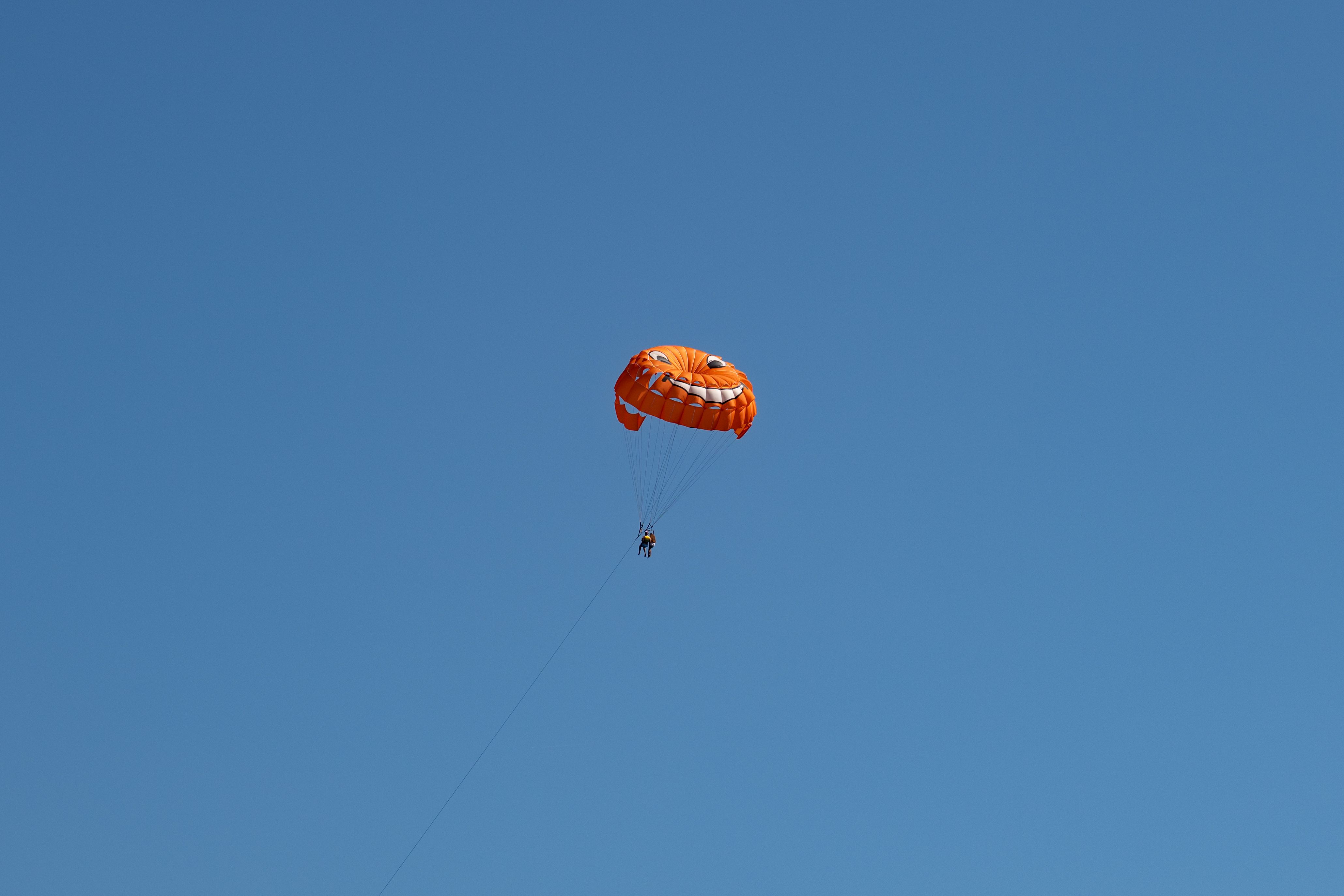 Orange parasail against clear blue sky in Primorsko-goranska, Croatia.