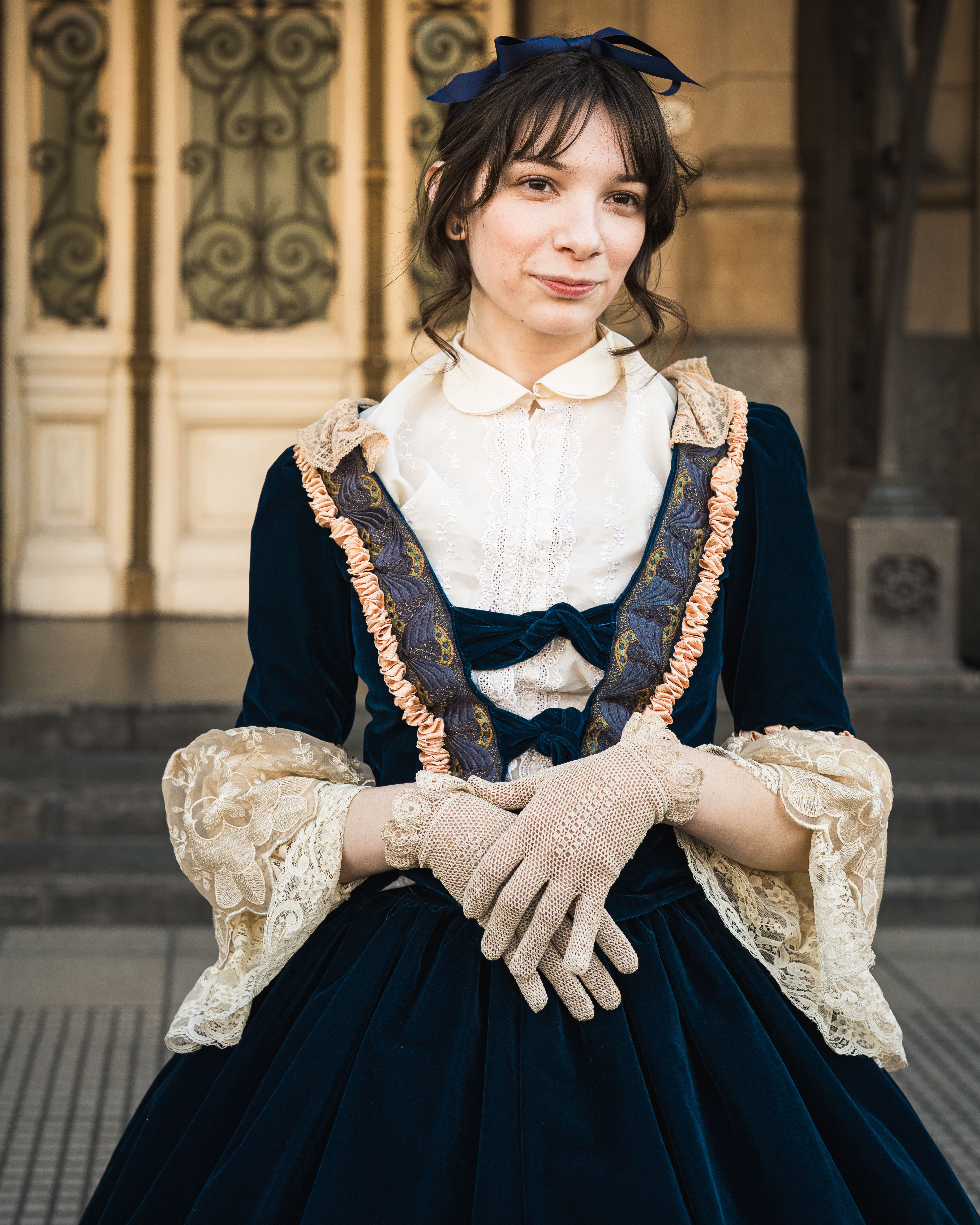 Portrait of a woman in a Victorian dress with lace details, posing outdoors.