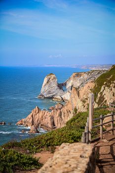 Captivating view of Cabo da Roca cliffs overlooking the Atlantic Ocean under a clear blue sky.