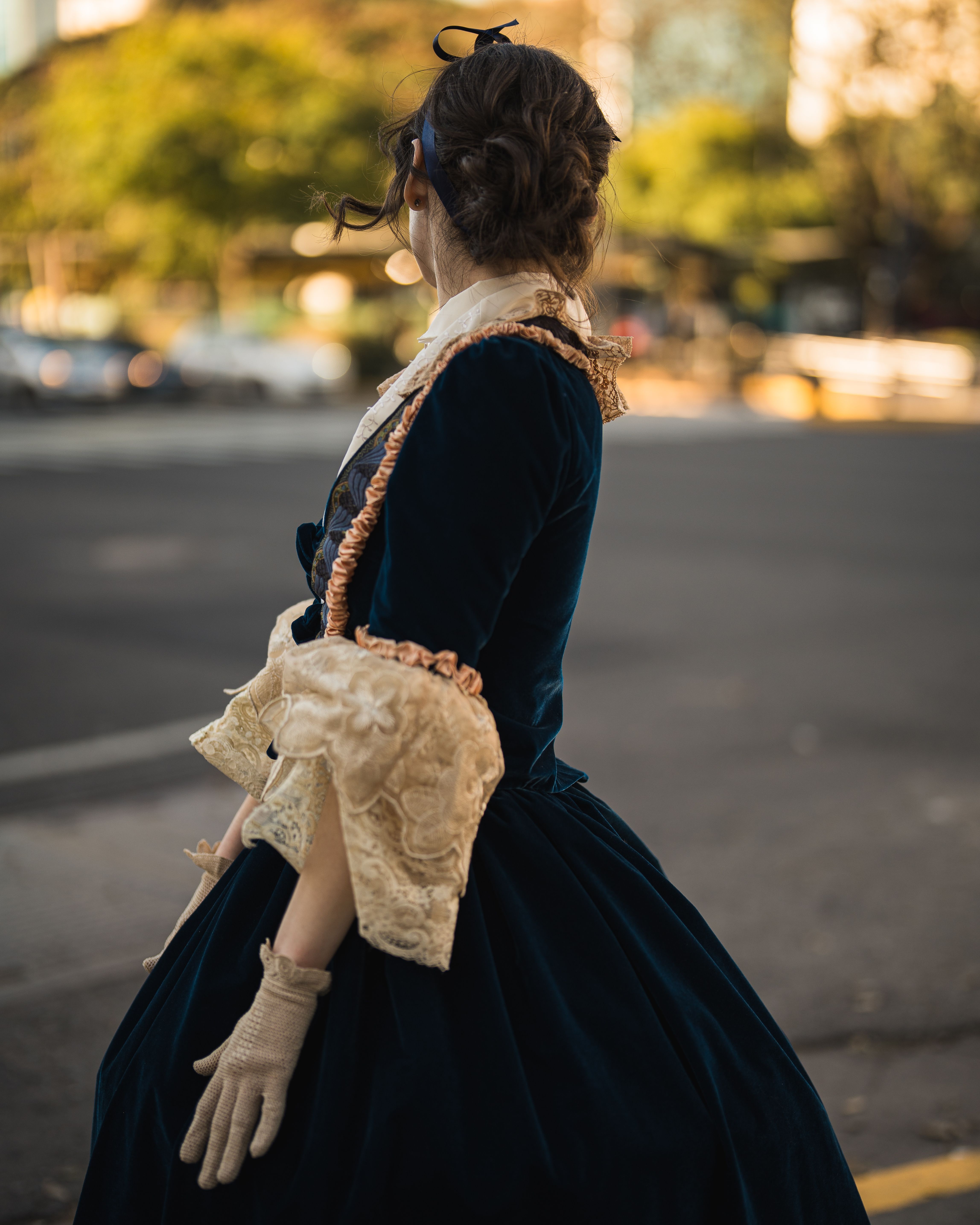 Woman in historical attire stands on urban street. Captivating cityscape.