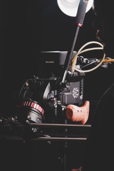 Close-up of a professional film camera setup in a dimly lit studio environment.