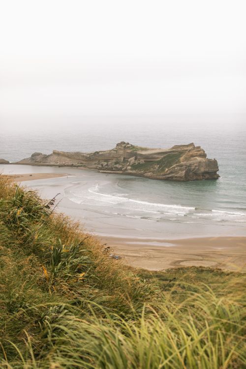 Free Serene beach view with dense fog at Castlepoint, New Zealand's Wellington region. Stock Photo