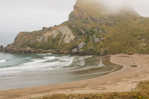 Free Explore the foggy coastline and beach of Castlepoint, New Zealand. Perfect for travel and nature enthusiasts. Stock Photo
