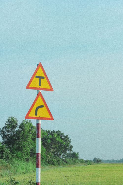 Free Image of rural road signs with fields and blue sky in Vietnam Stock Photo