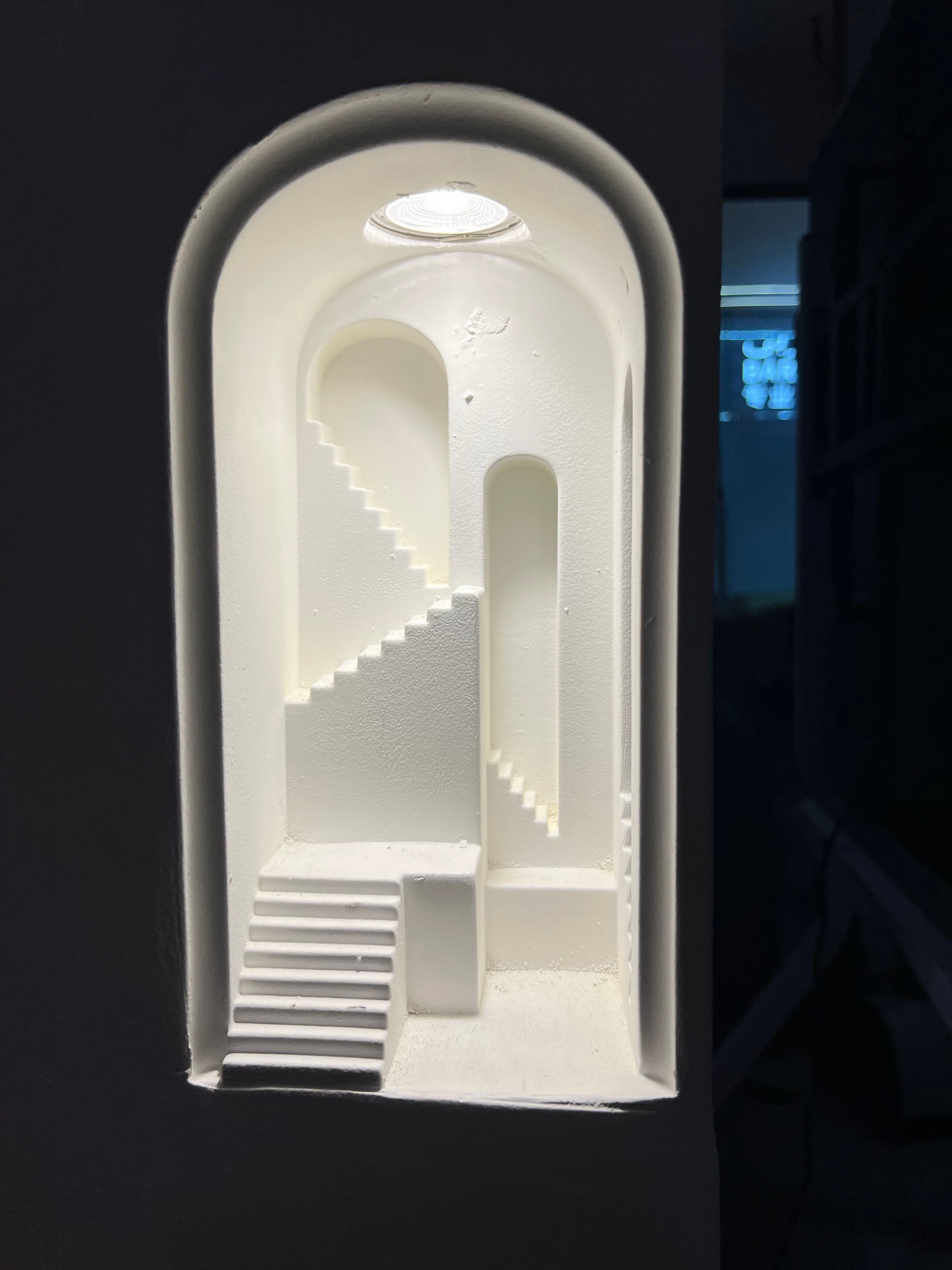 A sleek white architectural model showcasing a minimalist staircase design with soft lighting.