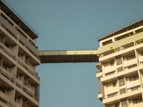 Free A modern skywalk between two buildings under a clear blue sky in Nashik, India. Stock Photo