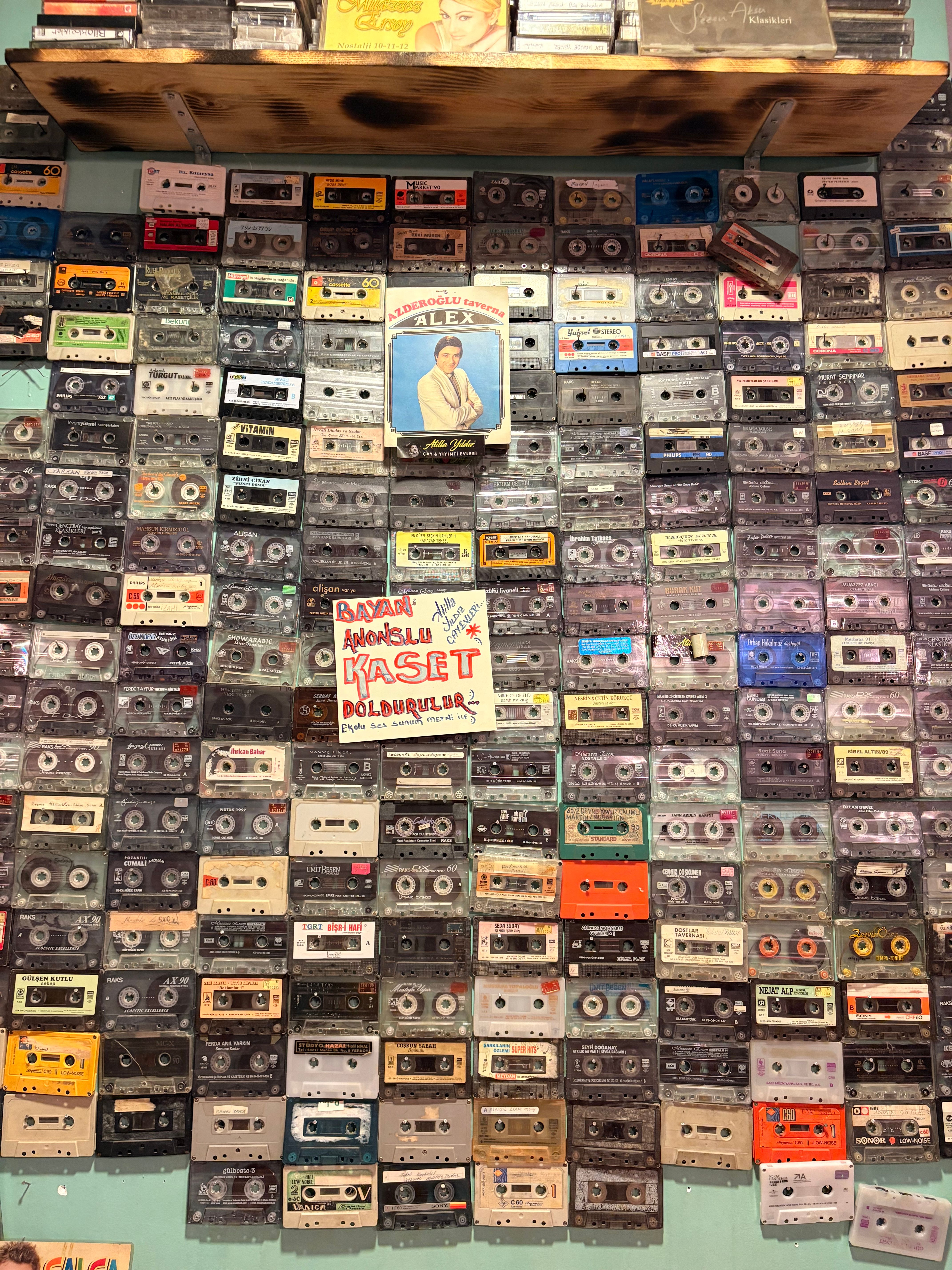 A diverse array of retro cassette tapes displayed on a store wall, showcasing music nostalgia.