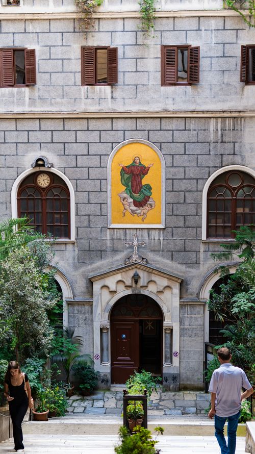 Free Elegant courtyard in Istanbul featuring an iconic fresco and lush greenery, capturing a moment of local life. Stock Photo