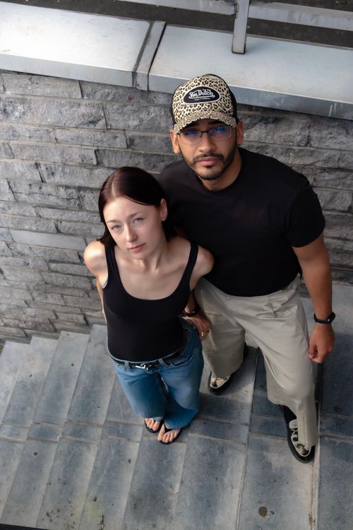 Free Young couple posing on a stone stairway, looking up at the camera outdoors. Stock Photo