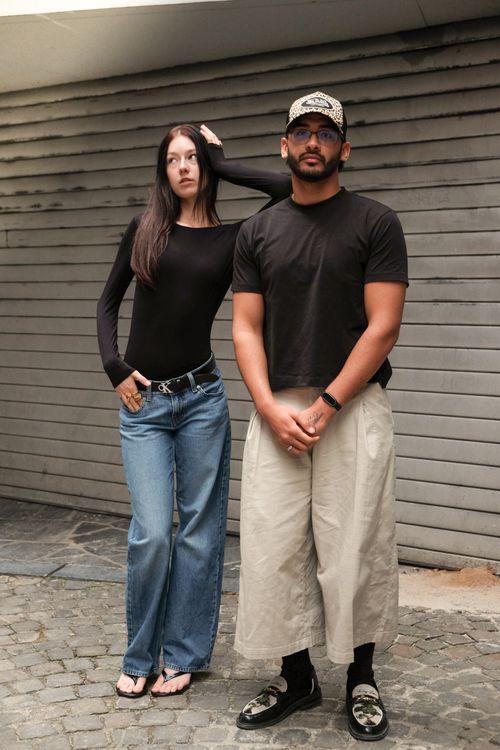 Free Two adults posing in stylish casual outfits against a modern backdrop. Stock Photo
