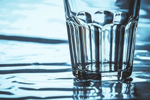 Free Close-up of a glass with intricate reflections on a water-like surface. Stock Photo