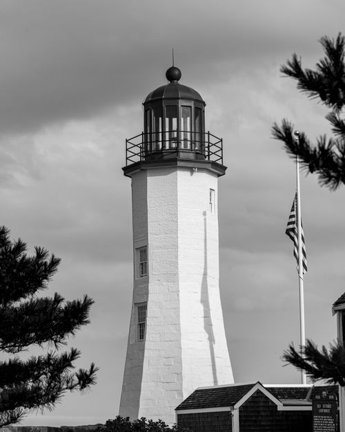 Free A striking black and white photo of Scituate Lighthouse capturing its iconic charm against cloudy skies. Stock Photo