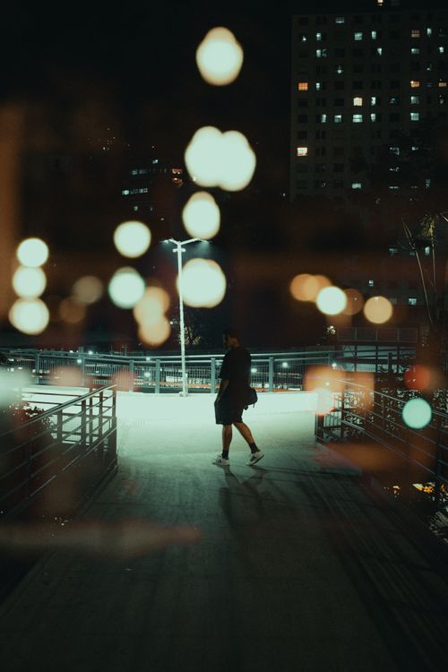 Free Night scene with bokeh lights and lone figure in São Paulo's urban setting. Stock Photo