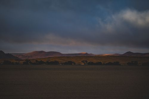 Free Beautiful sunset over the Namib Desert with dramatic skies and silhouetted dunes in Hardap, Namibia. Stock Photo