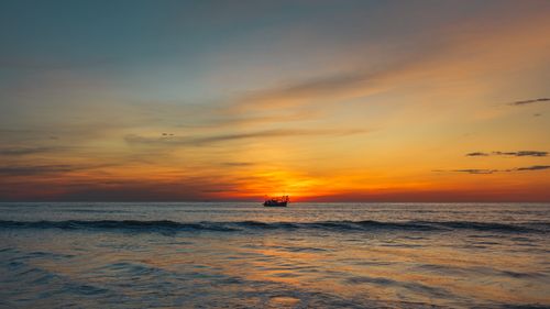 Free A serene sunset view with a boat on the horizon in Quảng Trị, Vietnam. Stock Photo