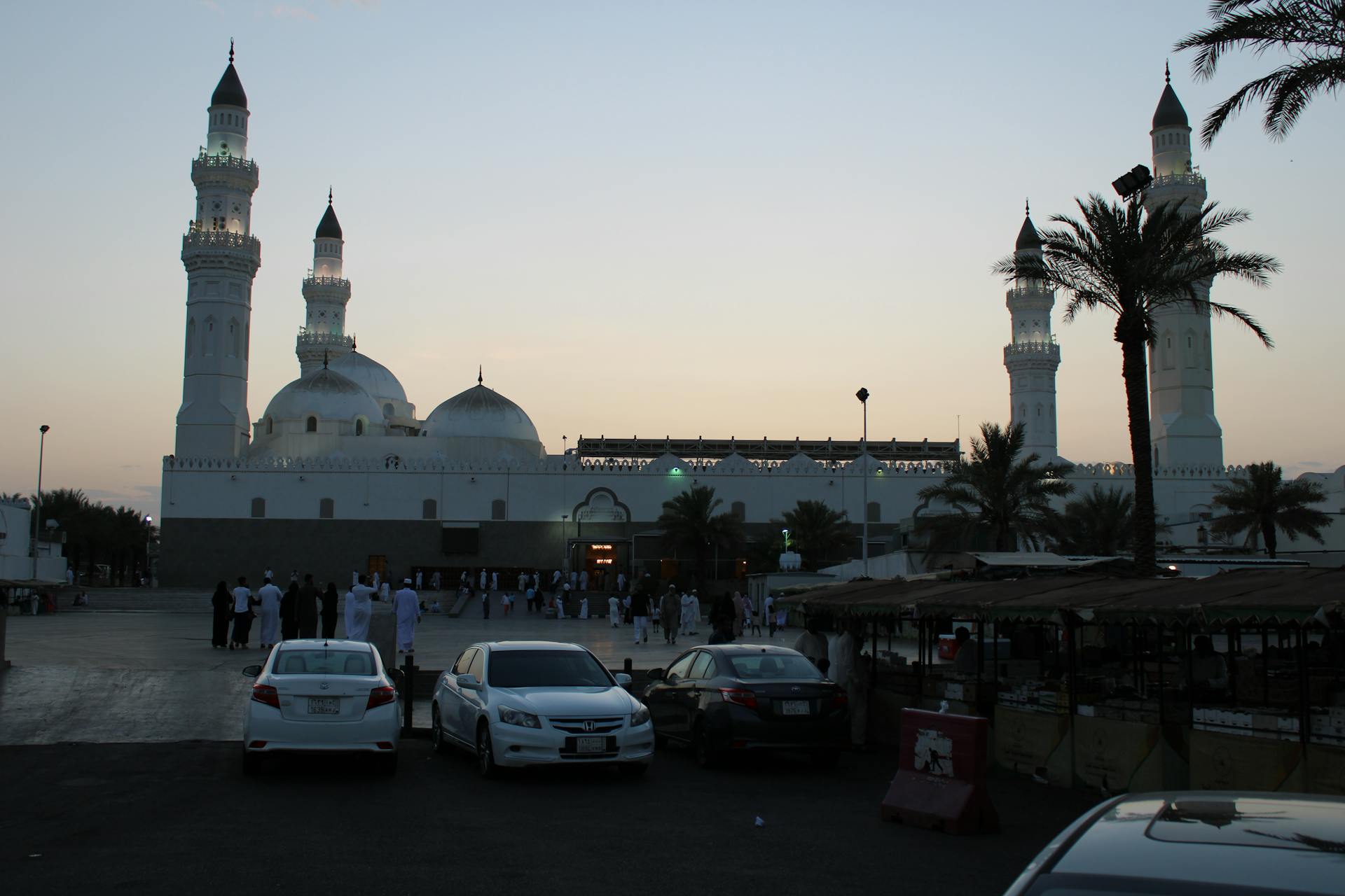 Beautiful twilight view of Quba Mosque in Medina, Saudi Arabia with people gathering.