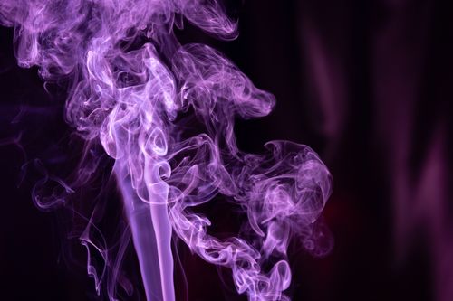 Free Ethereal and colorful purple smoke swirls gracefully against a dark backdrop, creating a mesmerizing abstract art piece. Stock Photo