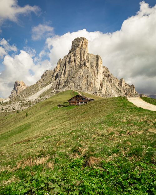 Free Picturesque cabin set against dramatic mountain peaks under a clear sky. Stock Photo