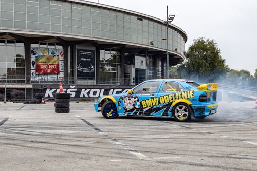 Free A customized car performing a drift outside a modern building in Belgrade, Serbia. Stock Photo