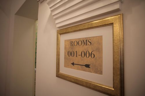 Free Sign with room numbers and arrow in golden frame hanging on white wall in modern hotel Stock Photo