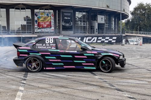 Free A vibrant drift car maneuvering in front of Belgrade Fair, capturing motorsport energy. Stock Photo