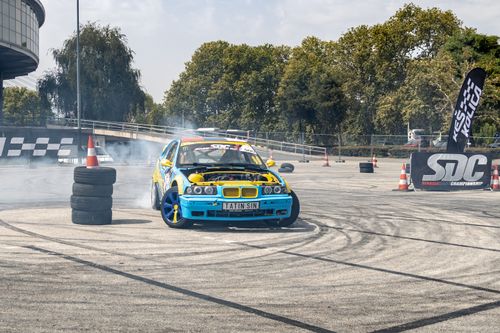 Free Blue-yellow race car drifting at Beograd event with tire smoke and spectators Stock Photo
