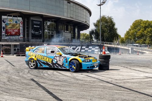 Free Dynamic car drift in Belgrade with vibrant sports car against architectural backdrop. Stock Photo