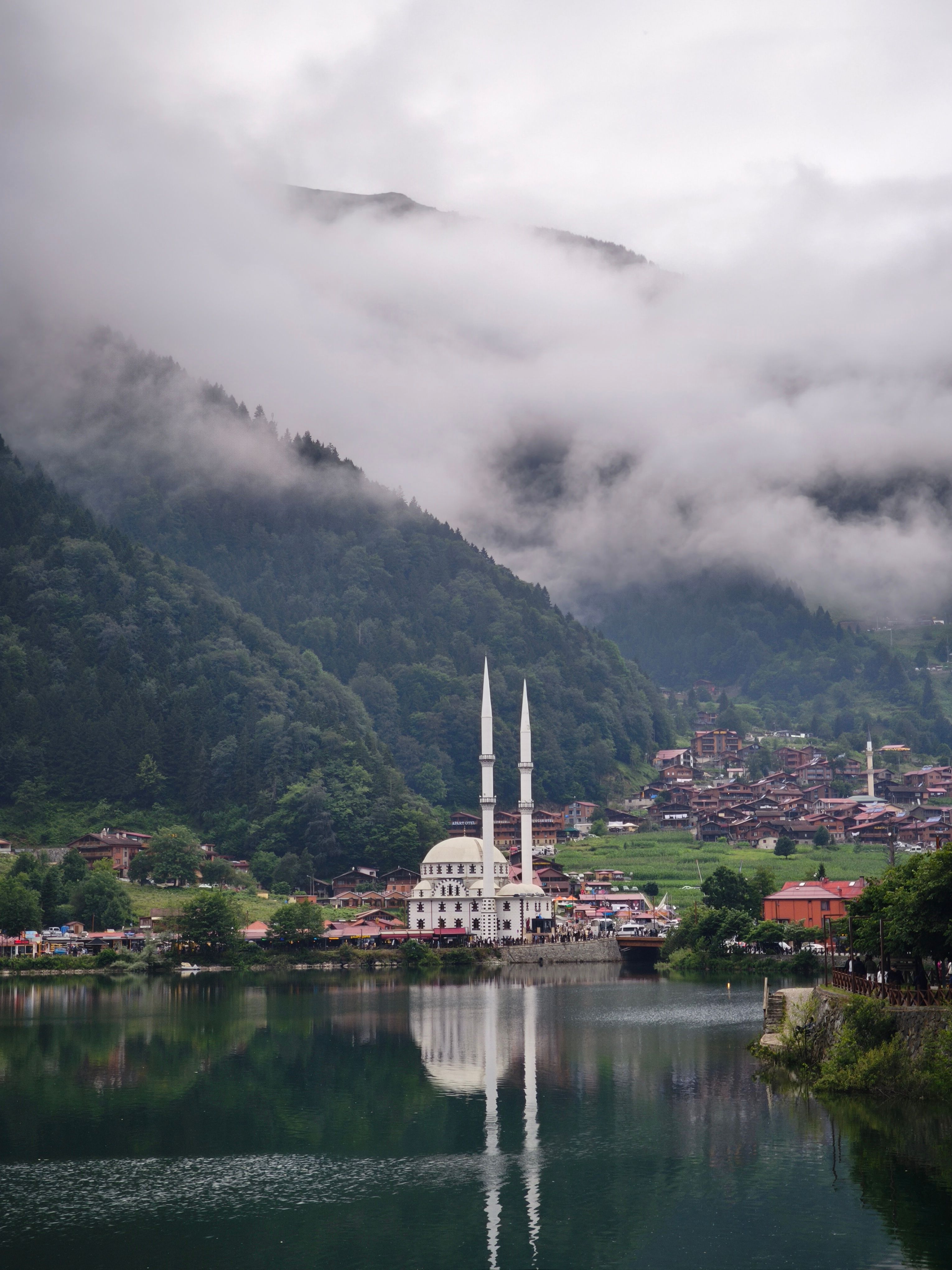 Explore the serene beauty of Uzungöl in Trabzon with misty mountains and a tranquil lake.