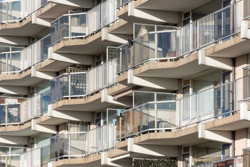 Free Close-up view of modern apartment building balconies with glass railings in sunlight. Stock Photo