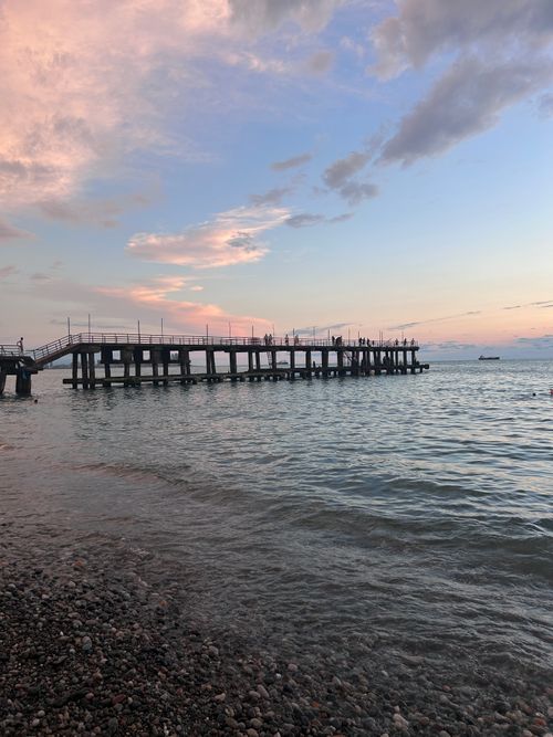 Free Serene view of a pier extending into the ocean at sunset, capturing peaceful ambiance. Stock Photo