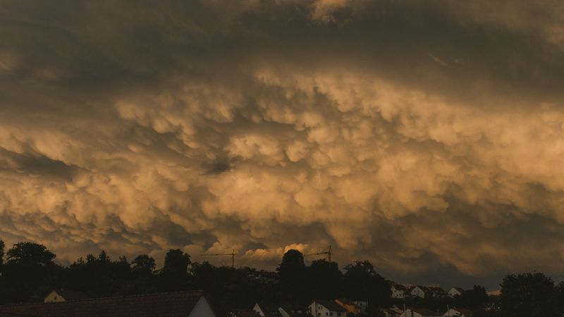 Dramatic storm clouds gathering over a suburban neighborhood