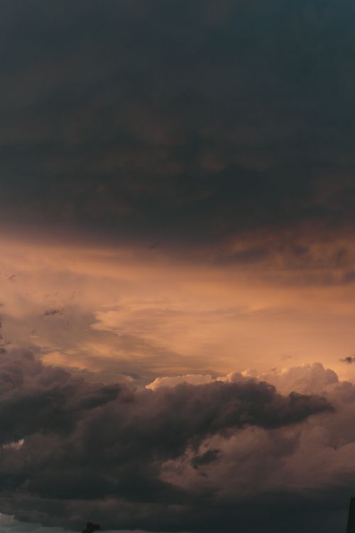 Free A striking sunset scene with dark storm clouds creating a dramatic atmosphere in the sky. Stock Photo