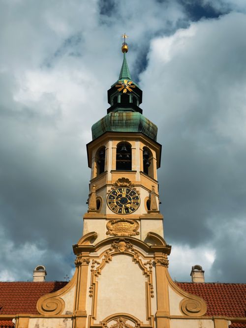 Free A stunning Baroque church tower and clock under dramatic skies in Prague. Stock Photo