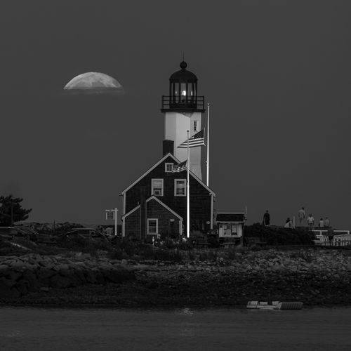 Free Scenic nighttime view of a lighthouse in Scituate, MA with a full moon in the background. Stock Photo