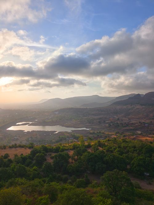 Free Breathtaking view of a mountain landscape with a lake under a sunrise sky. Stock Photo